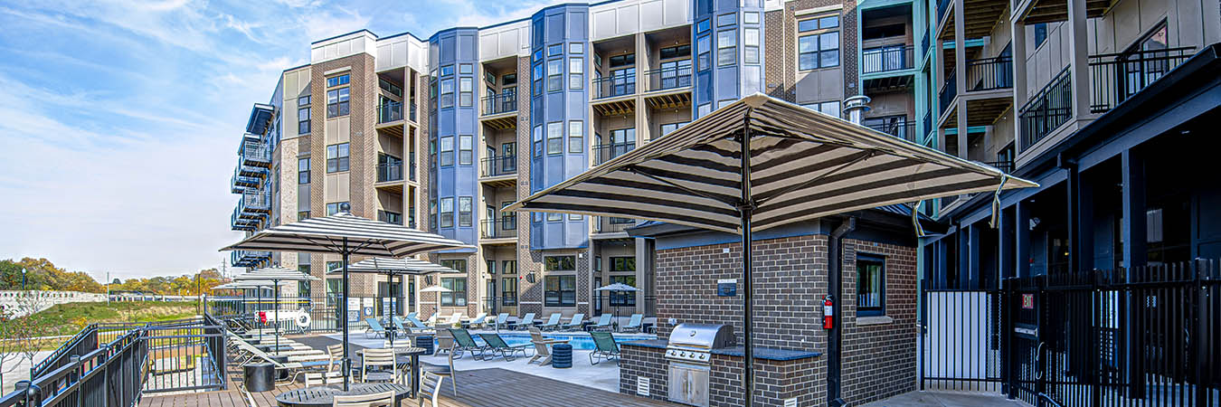 Deck and seating areas with umbrellas at East Bank Apartments in Noblesville.